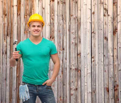 man wearing hard hat in front of fence
