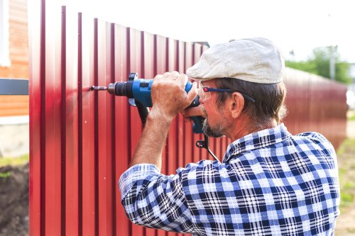 A professional repairing the fence