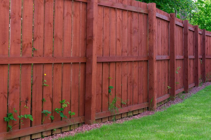 Red wooden privacy fence in a backyard in Palm Beach County, FL